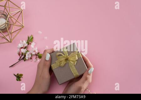 Dans les mains d'une jeune fille tenant une boîte cadeau. Maquette Banque D'Images