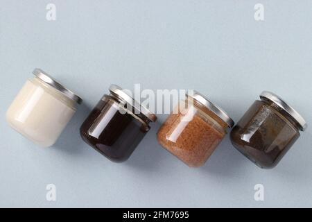 Pâte organique végétalienne de graines de lin, chardon, arachides et noix de coco dans des pots en verre sur fond bleu clair, urbech. Produit alimentaire sain. Vue depuis un Banque D'Images