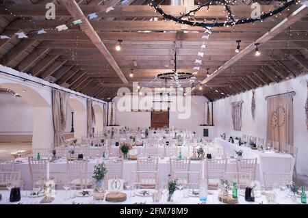 tabourets et chaises pour un mariage rustique de grange avec poutres de toit en montre Banque D'Images