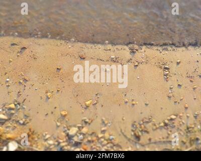 Vagues, rochers, sable avec accent sur le centre comme un fond naturel. Banque D'Images