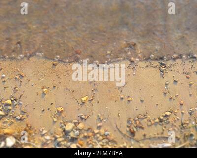 Vagues, rochers, sable avec accent sur le centre comme un fond naturel. Banque D'Images