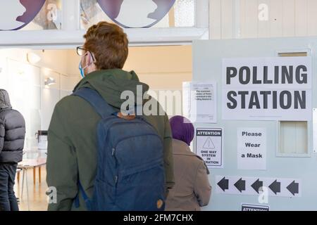 Les électeurs font la queue au bureau de vote pour les élections britanniques de 2021, le 6 mai. « Super jeudi », un monstre électoral, sac à dos, Angleterre Banque D'Images