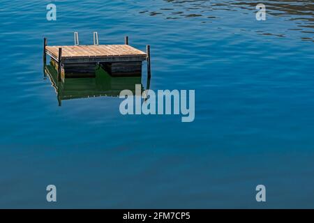 Photo minimaliste d'une plate-forme en bois pour les bains de soleil et les nageurs Sur le lac suisse de Lugano Banque D'Images