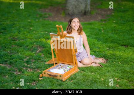 Petite Jeune Femme asiatique étudiant peinture dans le parc utilisation Une armoire Easel Banque D'Images