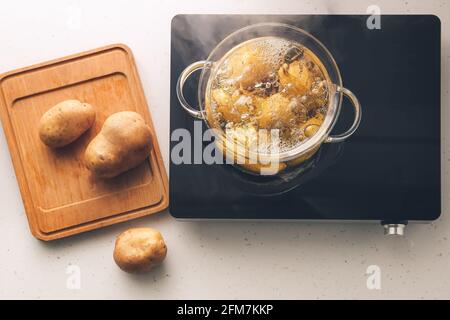 Casserole avec pommes de terre bouillante sur cuisinière électrique Banque D'Images