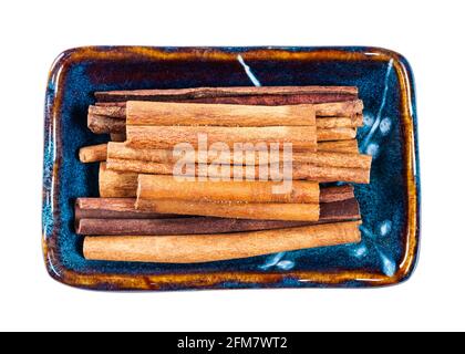 vue de dessus des bâtonnets de cannelle de cassia dans un bol en céramique découpe sur fond blanc Banque D'Images