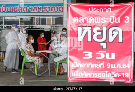 Nonthaburi, Thaïlande. 07e mai 2021. Les vendeurs portant un masque facial attendent qu'un agent de santé recueille des échantillons d'écouvillonnages nasaux sur un marché frais dans la province de Nonthaburi, dans la banlieue de Bangkok. Le ministère de la Santé publique a signalé vendredi 27 autres décès liés à Covid, pour un nombre de 363 et 2,044 nouveaux cas, ce qui porte le total à 78,855. (Photo de Chaiwat Subprasom/SOPA Images/Sipa USA) crédit: SIPA USA/Alay Live News Banque D'Images