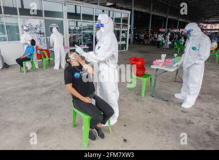 Nonthaburi, Thaïlande. 07e mai 2021. Un agent de santé recueille un échantillon d'écouvillonnage nasal auprès d'une femme sur un marché frais dans la province de Nonthaburi, à la périphérie de Bangkok. Vendredi, le ministère de la Santé publique a signalé 27 autres décès liés à Covid, pour un nombre de 363 et 2,044 nouveaux cas, portant le total à 78,855. Crédit : SOPA Images Limited/Alamy Live News Banque D'Images