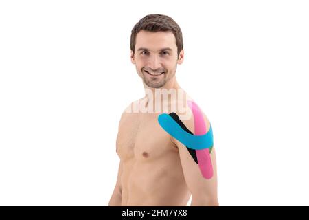 Épaule mâle avec bande physio, isolée sur fond blanc. Portrait de l'homme avec du ruban Kinesio sur le corps Banque D'Images