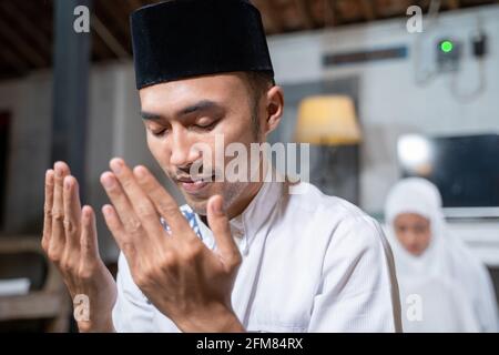 mari et femme musulmans priant la jamaah ensemble à la maison Banque D'Images
