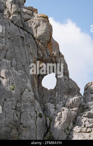 Roche calcaire, montagne avec trou naturel en elle, Llano del Hondonero, Villanueva del Rosario, Andalousie, sud de l'Espagne. Banque D'Images