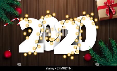 2020, blancs, nombres volumétriques bobinés de guirlande sur fond de bois avec des cadeaux, des boules, des cannes de bonbons et des branches d'arbre de Noël, vue du dessus Banque D'Images