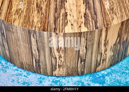 Élégante table à café ronde texturée contemporaine en contreplaqué et Placage naturel Ofram noir sur moquette bleue dans la chambre Banque D'Images