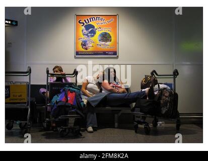 PASSAGERS RETARDÉS À L'AÉROPORT DE GATWICK JUILLET 2001 L'ÉTÉ COMMENCE ICI une publicité sur le mur de Gatwick. Les passagers attendent, se précipitent, se reposent sur la file d'attente, etc. Tous les éléments de l'existence quotidienne des gatewicks, à l'avance sont les vacances d'été et encore plus de retards et d'annulations prévus pour le public voyageur. Banque D'Images