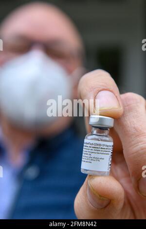 07 mai 2021, Saxe-Anhalt, Halberstadt: Klaus Begall, professeur à la clinique Ameos de Halberstadt, présente un flacon vide qui contenait autrefois des doses du vaccin de Biontech-Pfizer. Le flacon est l'un de ceux qui ont déjà été vaccinés en Allemagne le 26 décembre 2021, à la clinique Ameos, alors que la vaccination contre le coronavirus a commencé à Halberstadt un jour plus tôt que prévu dans tout le pays. Le matin, plusieurs de ces flacons avaient été remis au musée municipal. Les collections municipales contiennent des documents historiques contemporains et des objets de grande importance. Photo: Klaus-Dietmar Gabbert/dpa Banque D'Images