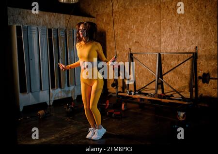 une fille sportive saute sur une corde dans une salle de gym moderne. photos en mouvement Banque D'Images