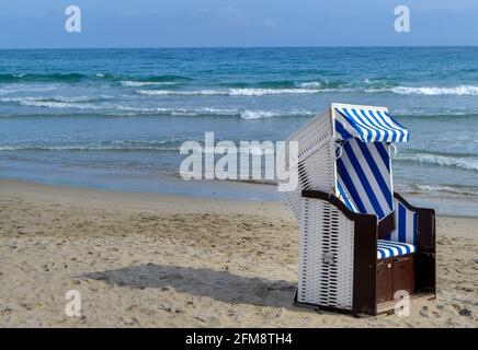 Chaise de plage couverte en osier sur la plage avec vue sur les vagues de la mer du nord Banque D'Images