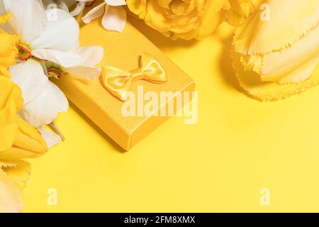 Aménagement jaune avec fleurs et boîte cadeau. Copier l'espace pour le texte. Banque D'Images
