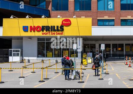 Les gens qui font la queue à l'extérieur d'un magasin d'alimentation de Nofrills durant l'époque du coronavirus ou du Covid-19 à Toronto, au Canada Banque D'Images