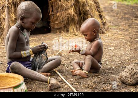 Deux jeunes enfants de Mursi jouent ensemble. DEBUB OMO ZONE, ETHIOPIE: RENCONTREZ LA tribu où les femmes commencent à étirer leurs lèvres avec de grandes assiettes à l'âge Banque D'Images