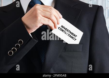 Homme d'affaires prend une carte de visite avec le mot conseil d'investissement. Concept de consultant en investissement d'entreprise. Banque D'Images