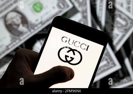 21 avril 2021, Chine: Dans cette illustration de la photo, le logo de la marque italienne de mode de luxe Gucci vu sur un smartphone avec une devise USD (dollar des Etats-Unis) en arrière-plan. (Image de crédit : © Budrul Chukrut/SOPA Images via ZUMA Wire) Banque D'Images