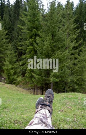 Pieds et jambes sur un pré vert avec des montagnes carpathes comme arrière-plan. Bucovina, Roumanie Banque D'Images