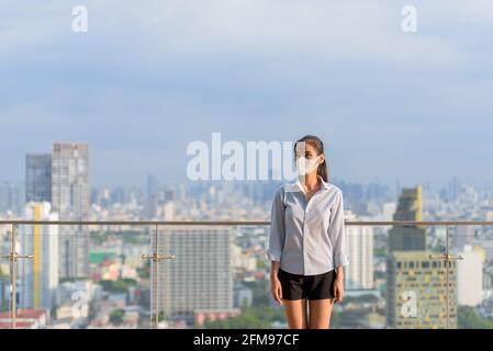 Femme asiatique portant un masque pour protéger contre le coronavirus Covid-19 tir horizontal Banque D'Images