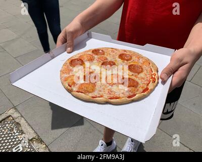 ROM, Italie. 07e mai 2021. Un homme montre une pizza achetée au 'Mr. Distributeur automatique Go. Dans la capitale italienne Rome, 'Mr. Le distributeur automatique de pizzas Go' partage l'opinion sur le classique de la restauration rapide italienne. Credit: Johannes Neudecker/dpa/Alamy Live News Banque D'Images