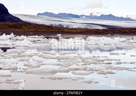 La glace du glacier Breioamerkurjokull (arrière) flotte dans le lac du glacier Fjallsarlon, dans le parc national de Vatnajokull, en Islande. Banque D'Images