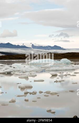 La glace du glacier Breioamerkurjokull (arrière) flotte dans le lac du glacier Fjallsarlon, dans le parc national de Vatnajokull, en Islande. Banque D'Images