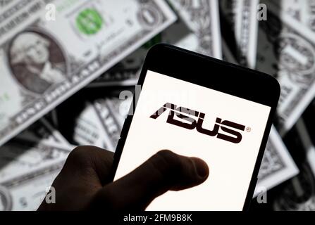 Dans cette illustration photo, le logo Asus de la société multinationale taïwanaise de matériel informatique et de téléphone et d'électronique s'affiche sur un smartphone avec une devise en dollars américains (USD) en arrière-plan. (Photo de Budrul Chukrut / SOPA Images/Sipa USA) Banque D'Images