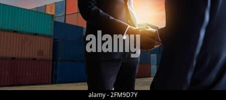 concept d'entreprise d'exportation et d'importation de fret. Gros plan des hommes d'affaires en train de se serrer la main au terminal des conteneurs industriels. Transport maritime et logistique Banque D'Images