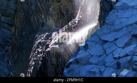 Italie, Sicile, Alcantara, gorge d'Alcantara, rivière, cascade, l'eau tombe sur une corniche dans la gorge, l'eau éclabousse comme un jet, le rétroéclairage, les murs de roche bleuâtre Banque D'Images