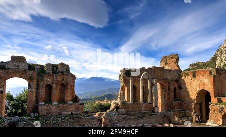 Italie, Sicile, Taormine, théâtre antique, amphiteater, GRECO-Roman, construit au 3ème siècle av. J.-C., au 2ème siècle après J.-C. reconstruit par les Romains, une vue de la scène et de l'orchestre et de l'Etna, ciel paysan, de longs nuages Banque D'Images