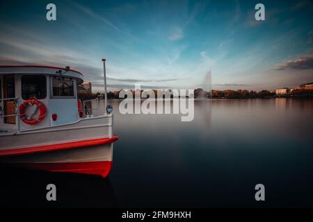 Lac Alster avec bateau à vapeur traditionnel pour une croisière sur l'eau à Hambourg, Allemagne. Paysage urbain à longue exposition. Banque D'Images