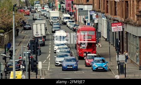 Glasgow, Écosse, Royaume-Uni. 7 mai 2021. Météo au Royaume-Uni : La détente ensoleillée du confinement a vu beaucoup de marche avec peu de choses à faire alors que les gens se promenaient seuls et s'asseyaient beaucoup.le bus rouge du restaurant continue son aspect incongru comme l'ancien maître de la route de Londres maintenant un restaurant Red bus Bistro est coincé aux feux de circulation sur la route des bois dans sa pittoresque visite de la ville avec thé l'après-midi. Crédit : Gerard Ferry/Alay Live News Banque D'Images