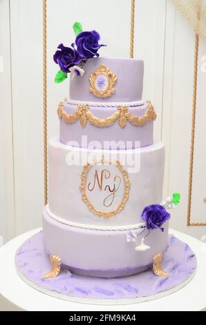 Gâteau de mariage violet et blanc. Avec les premières lettres du nom du couple Banque D'Images