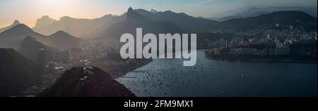 Magnifique vue panoramique sur Rio de Janeiro, le paysage brésilien, la montagne Corcovado avec la statue du Christ Rédempteur et la baie de Botafogo au coucher du soleil Banque D'Images