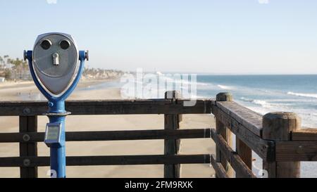 Observateur de tour d'observation stationnaire métallique, jumelles anciennes au bord de l'eau, jetée d'Oceanside, Californie, États-Unis. Télescope rétro à pièces sur le front de mer, vue sur la côte maritime, observation estivale de la plage océanique Banque D'Images