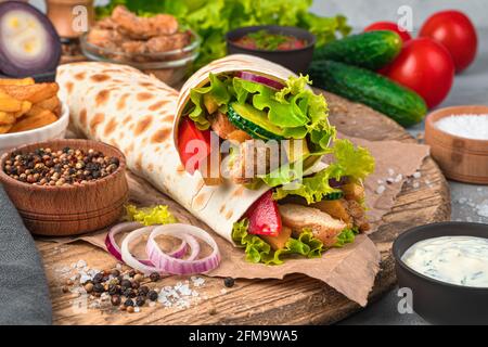 Shawarma gros plan sur un fond gris avec des ingrédients. Restauration rapide. Vue latérale, gros plan. Banque D'Images