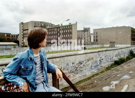 Mur de Berlin, juillet 1984, jeune homme regardant le mur Banque D'Images