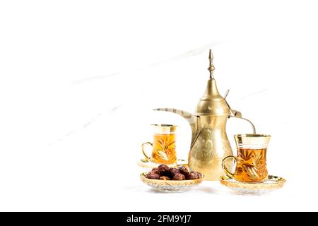 Décoration de table orientale. Verres à thé avec dattes sur fond blanc Banque D'Images