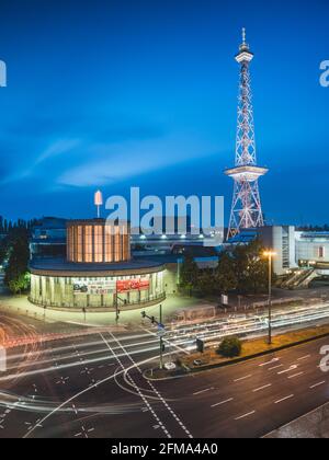 Circulation routière en face de la tour de radio illuminée de Berlin sur le parc des expositions au crépuscule. Banque D'Images