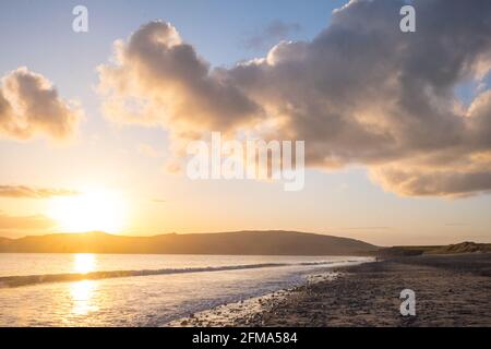 Coucher de soleil,coucher,coucher,soleil,Port Neigwl,Porth Neigwl Beach,également connu sous le nom de, aka, Hell's Mouth,spectaculaire,nuage,nuages,sur,populaire,surf,plage,front de mer,village,Ouest,Mid,North Wales,,comté,Welsh Summer Vacation,resort.United Kingdom,GB,GB,Europe,Porth Bay,Llŷn, large Bay, est également connu dans la péninsule de Neigwl, à 3 km au sud de la baie de la baie de la baie de Neigwell, dans le pays de Galles.La baie fait face au sud-ouest et se situe entre les promontoires de Mynydd Rhiw à l'ouest et de Mynydd Cilan à l'est Banque D'Images