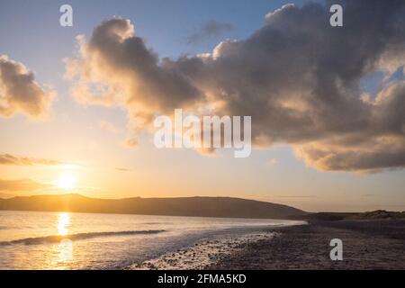 Coucher de soleil,coucher,coucher,soleil,Port Neigwl,Porth Neigwl Beach,également connu sous le nom de, aka, Hell's Mouth,spectaculaire,nuage,nuages,sur,populaire,surf,plage,front de mer,village,Ouest,Mid,North Wales,,comté,Welsh Summer Vacation,resort.United Kingdom,GB,GB,Europe,Porth Bay,Llŷn, large Bay, est également connu dans la péninsule de Neigwl, à 3 km au sud de la baie de la baie de la baie de Neigwell, dans le pays de Galles.La baie fait face au sud-ouest et se situe entre les promontoires de Mynydd Rhiw à l'ouest et de Mynydd Cilan à l'est Banque D'Images