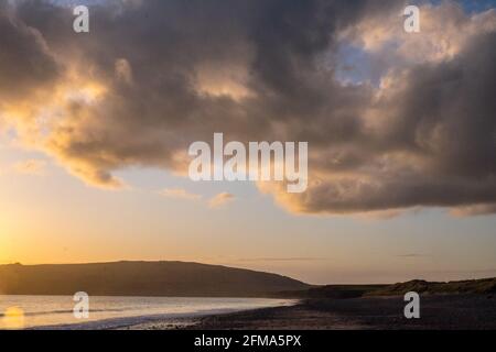 Coucher de soleil,coucher,coucher,soleil,Port Neigwl,Porth Neigwl Beach,également connu sous le nom de, aka, Hell's Mouth,spectaculaire,nuage,nuages,sur,populaire,surf,plage,front de mer,village,Ouest,Mid,North Wales,,comté,Welsh Summer Vacation,resort.United Kingdom,GB,GB,Europe,Porth Bay,Llŷn, large Bay, est également connu dans la péninsule de Neigwl, à 3 km au sud de la baie de la baie de la baie de Neigwell, dans le pays de Galles.La baie fait face au sud-ouest et se situe entre les promontoires de Mynydd Rhiw à l'ouest et de Mynydd Cilan à l'est Banque D'Images