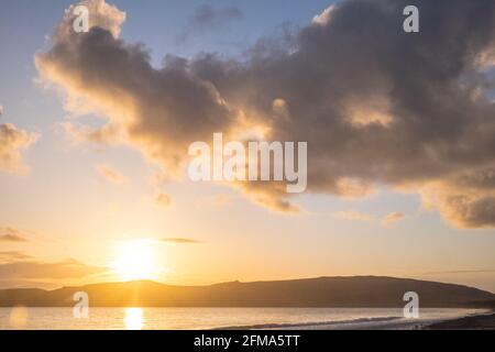 Coucher de soleil,coucher,coucher,soleil,Port Neigwl,Porth Neigwl Beach,également connu sous le nom de, aka, Hell's Mouth,spectaculaire,nuage,nuages,sur,populaire,surf,plage,front de mer,village,Ouest,Mid,North Wales,,comté,Welsh Summer Vacation,resort.United Kingdom,GB,GB,Europe,Porth Bay,Llŷn, large Bay, est également connu dans la péninsule de Neigwl, à 3 km au sud de la baie de la baie de la baie de Neigwell, dans le pays de Galles.La baie fait face au sud-ouest et se situe entre les promontoires de Mynydd Rhiw à l'ouest et de Mynydd Cilan à l'est Banque D'Images