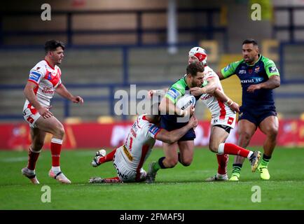 L'Aidan Sezer de Huddersfield Giants est affronté par le Theo Fages de St Helens (deuxième à droite) et par Joel Thompson lors du quart de finale de la coupe du défi de Betfred au stade Emerald Headingley, à Leeds. Date de la photo: Vendredi 7 mai 2021. Banque D'Images