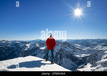 Mountaineer dans un paysage de montagne enneigé lors d'une journée d'hiver ensoleillée au sommet du Rauhorn. Alpes d'Allgäu, Tyrol, Autriche, Europe Banque D'Images
